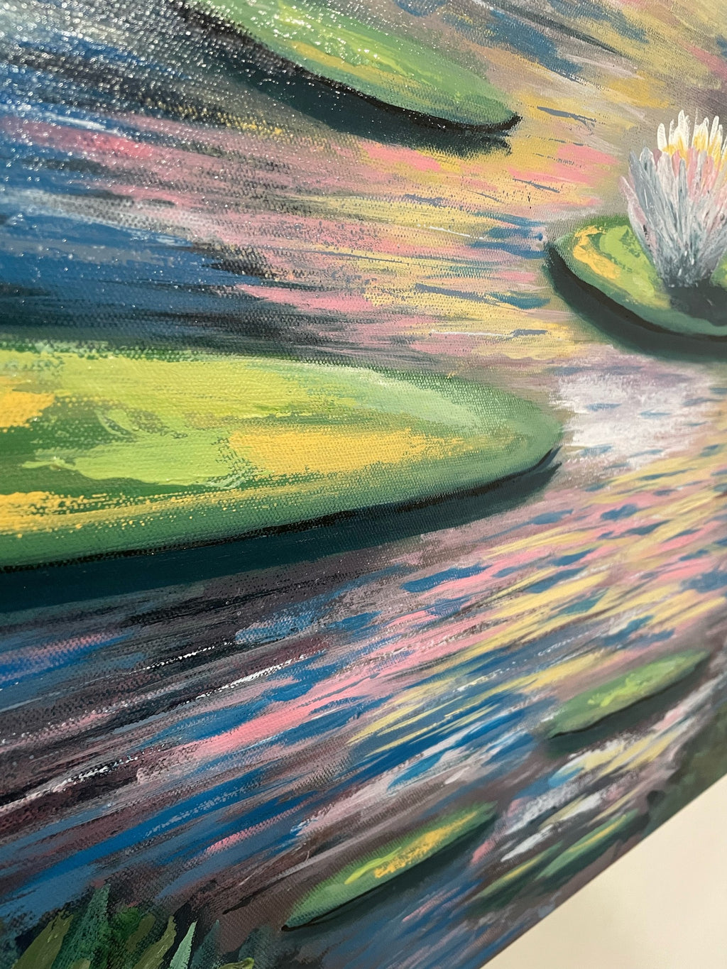 No One Likes Me original acrylic painting detail: angled view of green lily pads floating on pink, gold and blue reflections, with textured brushstrokes and a white water lily at the edge